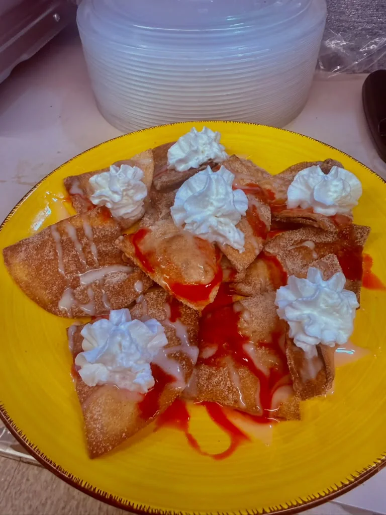 Sopapilla with whipped cream and strawberry drizzle